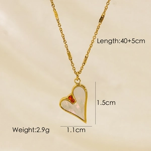 Detail of heart pendant necklace with gold finish, white shell inlay and red cubic zirconia