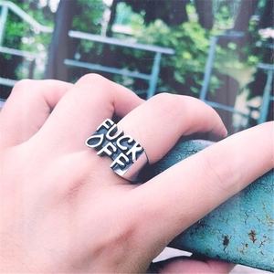Detailed close-up of a silver punk ring with FUCK OFF embossed lettering on a wide band
