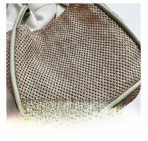 Detail showing high-quality straw weave texture and light green leather edge of tote bag