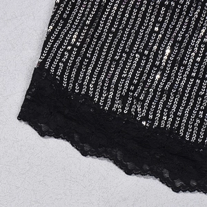 Gros plan sur les paillettes noires et la dentelle délicate d'un crop top dos nu
