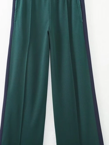 Détail du pantalon large vert foncé avec rayures bleu marine et texture dense