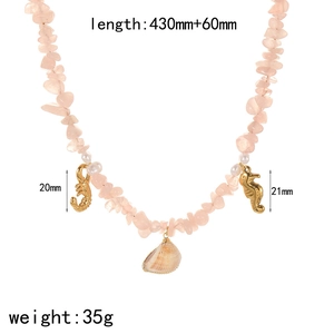 Dettaglio della collana di perle in cristallo rosa con ciondoli a scorpione e conchiglia