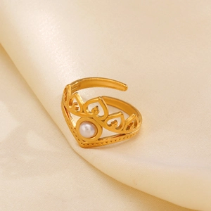 Elegant gold crown ring with a central pearl on a beige silk background