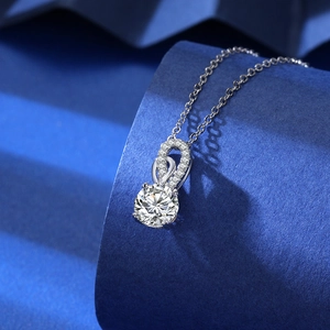 Detailed view of a silver necklace featuring a large round zircon with a twisted pave bail