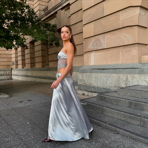 Détail de la robe en satin argenté avec empiècement en mesh et découpe à la taille chic