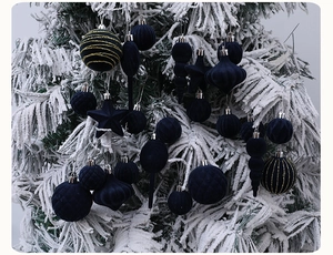 Detail von marineblauen beflockten und glitzernden Ornamenten an einem Schneebaum