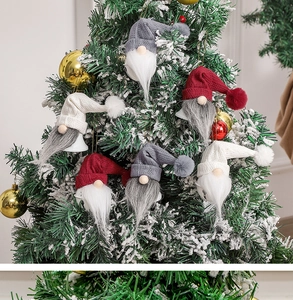 Close-up of Nordic Christmas gnome ornaments with bells hanging on a decorated tree