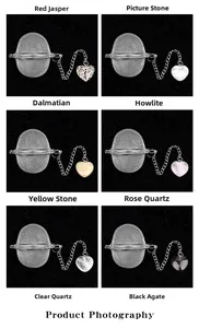 Detailed grid of stainless steel tea infusers with heart-shaped crystal stone pendants