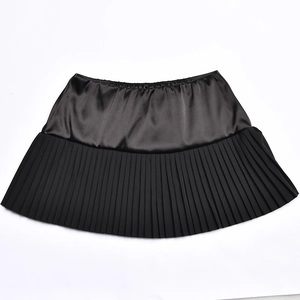 Detailed view of women's black mini skirt featuring satin splicing and pleated hem design