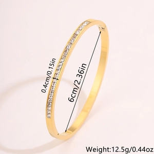 Detail view of gold titanium bangle showing dimensions 0.4cm width and 6cm diameter