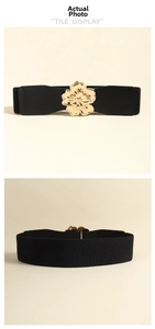 Détail d'une large ceinture élastique avec une grande boucle fleurie en métal doré