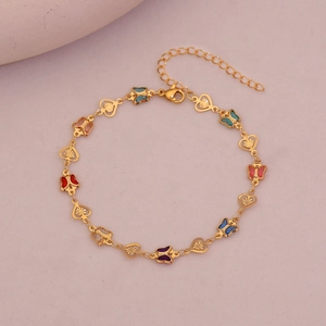 Detailed macro shot of gold ankle bracelet with colorful enamel butterfly charms