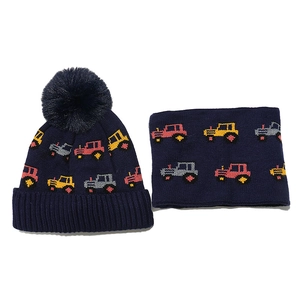 Detailed knit texture of navy blue kids' winter hat and scarf set with tractor pattern