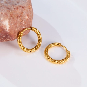 Minimalist gold geometric hoop earrings with diamond-cut texture on a natural stone base