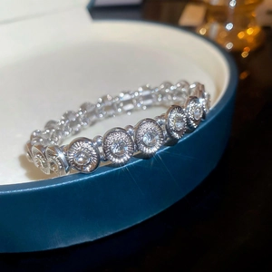 Detail shot of sparkling oval crystal clusters on silver-toned elastic stretch bracelet