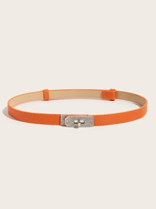 Detailed view of an orange slim leather belt featuring a silver rhinestone-studded lock buckle