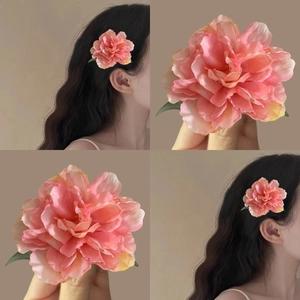 Detail of pink and yellow gradient silk flower hair clip with realistic fabric petals