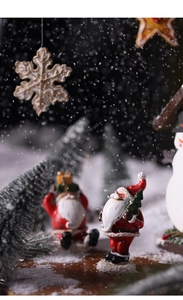 Macro detail of Santa Claus figurine with mini pine tree and artificial snow decoration