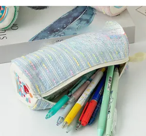 Detail of blue tweed pencil case showing large capacity interior and cute embroidery