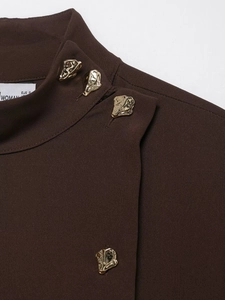 Close-up of elegant mock neck dress featuring stylish gold buttons and textured fabric