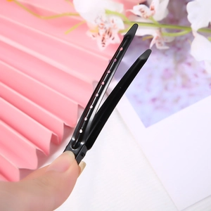 Close-up of a black metal hair claw clip with round hollow design and matte finish