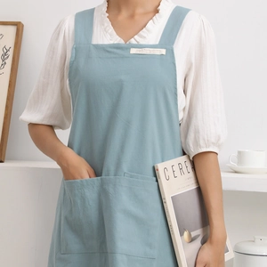 Minimalist light blue linen apron with H-shaped shoulder straps and front utility pocket