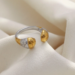 Vue détaillée d'une bague tête de serpent bicolore dorée et argentée sur tissu doux