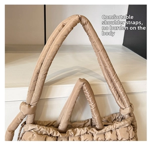 Detail of comfortable padded shoulder straps on a khaki quilted tote bag for women