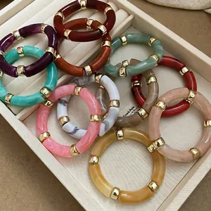 Iridescent acrylic geometric bracelets with gold spacer beads in a jewelry display tray