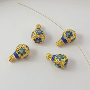 Macro detail of 18K gold-plated hot air balloon bead with blue enamel floral patterns