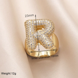 Macro shot of gold letter R ring with cubic zirconia showing 23mm height and 18mm diameter