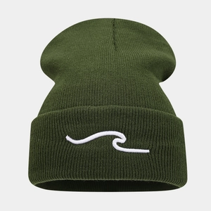 Close-up of olive green beanie with white wave embroidery and warm ribbed texture