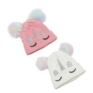 Détail de bonnets licorne en tricot avec paillettes, pompons colorés et broderies