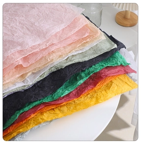 Close-up of vibrant wrinkled tissue paper layers in various colors for gift wrapping