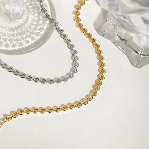 Gold and silver stainless steel heart-shaped woven chain bracelets on elegant white background