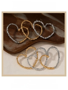Detail of hollow heart earrings with hammered texture in gold and silver finish