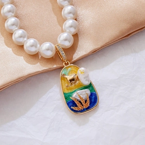 Baroque pearl necklace with deer enamel gold pendant on soft silk background