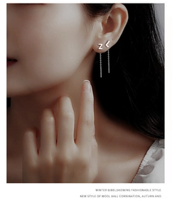 Detail of S999 sterling silver long chain tassel earring with letter Z pendant on model