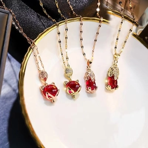 Golden cat eye fox and Pixiu pendants with red stones on a luxury jewelry tray