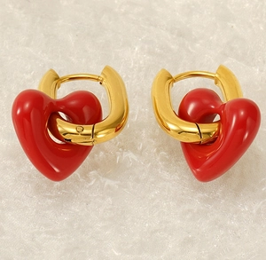 Detailed view of gold hoop earrings featuring vibrant red enamel heart pendants