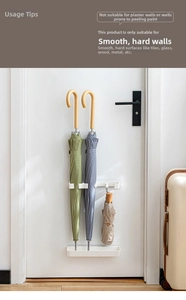Detail of wall-mounted umbrella rack with hooks and drip tray for home entryway