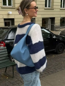 Detail of blue and white striped knit sweater paired with a matching fog blue shoulder bag