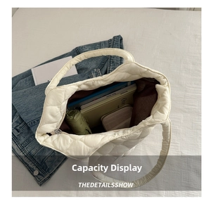 Top view showing large capacity interior of white quilted tote bag with daily items