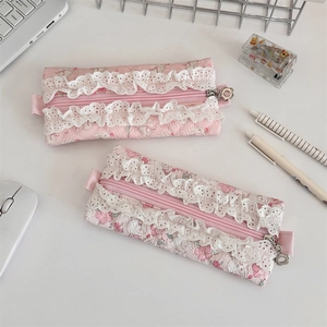 Quilted floral pencil case with pink lace trim and flower zipper on desk