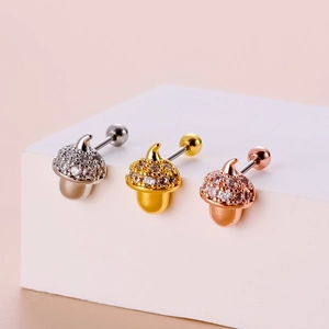 Macro detail of acorn stud earrings with sparkling cubic zirconia in three metal finishes
