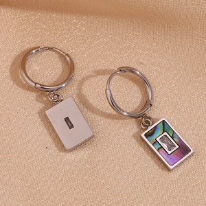 Detail of silver stainless steel earrings featuring abalone shell and zircon rectangle charms
