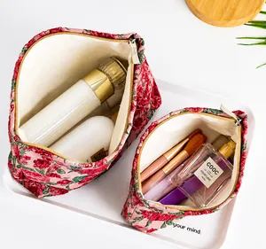 Dettaglio di trousse jacquard a fiori rossi con ampia capacità e cerniera in metallo resistente