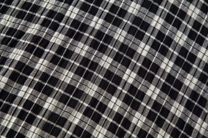 Gros plan sur la texture du tissu vichy noir et blanc montrant le tissage et les plis