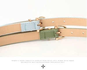 Close-up of slim PU leather belts in light blue and olive green with gold buckles