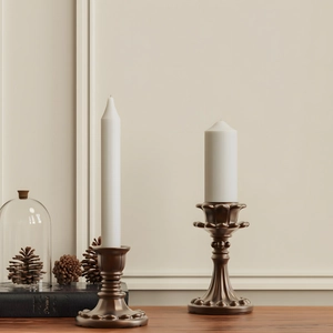 Detail van vintage bronzen kandelaars met reliëfbasis op een donkere houten tafelblad